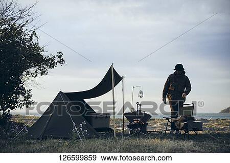 Stock Photo - Japanese man solo camping. Fotosearch