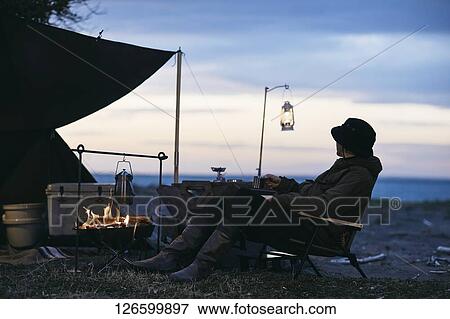 Stock Photo - Japanese man solo camping. Fotosearch