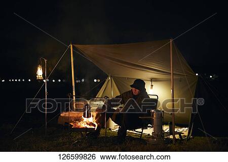 Stock Photograph - Japanese man solo camping. Fotosearch