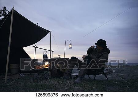 Stock Photograph - Japanese man solo camping. Fotosearch