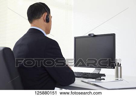 Stock Image - Japanese man working from home. Fotosearch