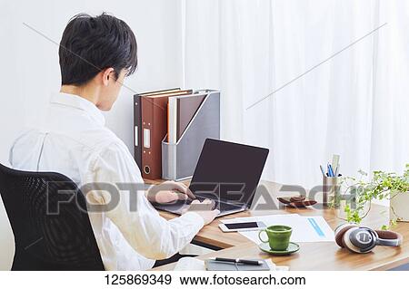Stock Photo - Japanese man working from home. Fotosearch
