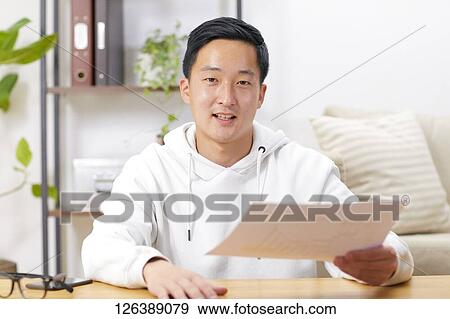 Stock Photo - Japanese man working from home. Fotosearch
