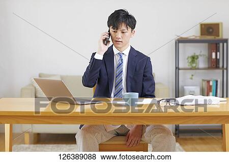 Stock Photo - Japanese man working from home. Fotosearch