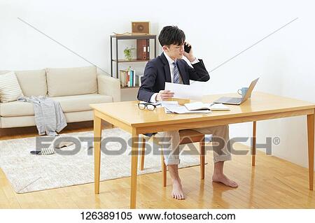 Stock Photography - Japanese man working from home. Fotosearch