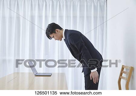 Stock Photography - Japanese man working from home. Fotosearch