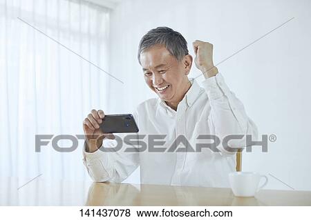 Stock Photo - Japanese Middle Aged Man Smiling In The Room. Fotosearch