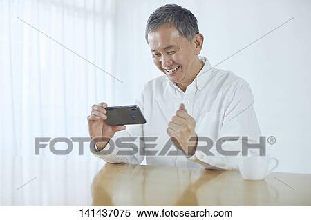 Stock Photography - Japanese Middle Aged Man Smiling In The Room. Fotosearch