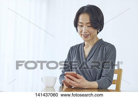 Stock Image - Japanese Middle Aged Woman Smiling In The Room. Fotosearch