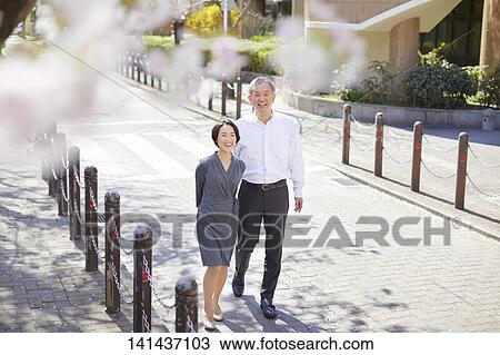 Stock Image - Japanese Senior Couple Smiling Outside. Fotosearch