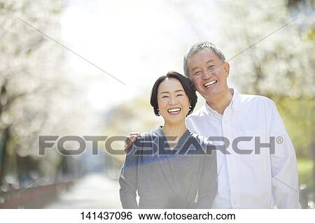 Stock Photograph - Japanese Senior Couple Smiling Outside. Fotosearch