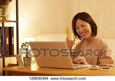 Japanese woman drinking at home remote drinking View Large Photo Image Picture - Japanese woman drinking at home remote drinking. Fotosearch