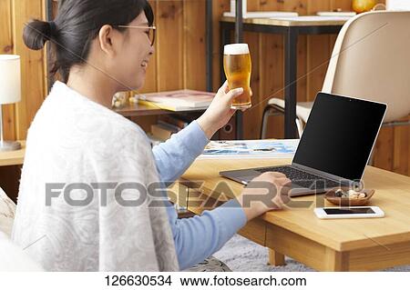 Japanese woman drinking at home remote drinking View Large Photo Image Picture - Japanese woman drinking at home remote drinking. Fotosearch