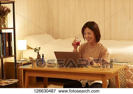 Japanese woman drinking at home remote drinking View Large Photo Image Stock Photo - Japanese woman drinking at home remote drinking. Fotosearch