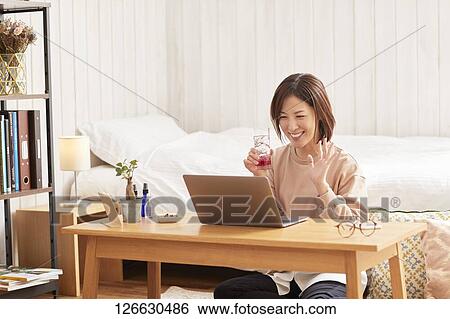 Japanese woman drinking at home remote drinking View Large Photo Image Stock Photograph - Japanese woman drinking at home remote drinking. Fotosearch