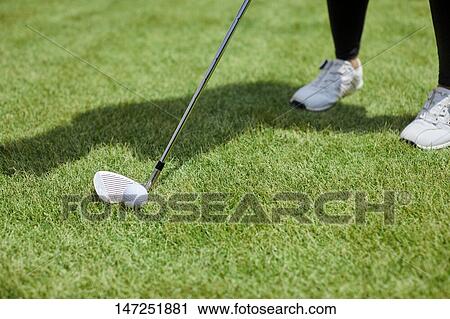 Stock Image - Japanese woman practicing golf in the garden. Fotosearch