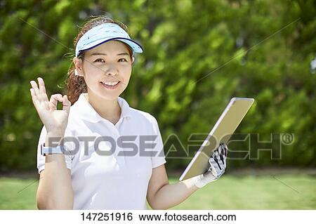 Stock Photograph - Japanese woman practicing golf in the garden. Fotosearch
