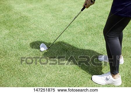 Stock Photography - Japanese woman practicing golf in the garden. Fotosearch