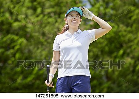 Stock Photography - Japanese woman practicing golf in the garden. Fotosearch