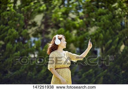 Stock Photo - Japanese woman relaxing in the garden. Fotosearch