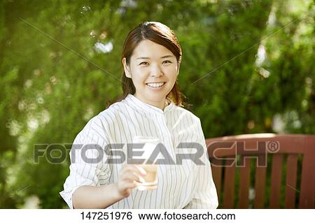 Japanese woman relaxing in the garden View Large Photo Image Stock Photograph - Japanese woman relaxing in the garden. Fotosearch