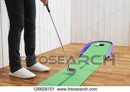 Stock Photo - Japanese woman training for golf at home. Fotosearch