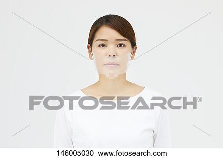 Stock Image - Japanese woman wearing face shield. Fotosearch