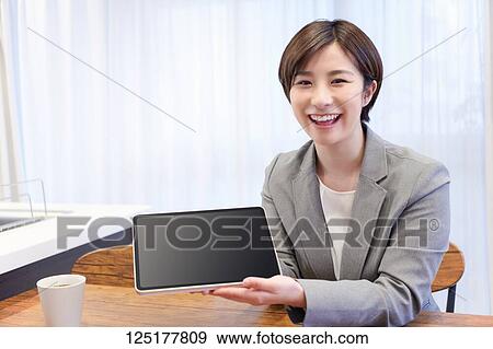 Stock Photo - Japanese woman working from home. Fotosearch