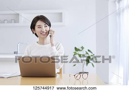 Japanese woman working from home View Large Photo Image Stock Photo - Japanese woman working from home. Fotosearch