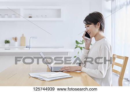 Japanese woman working from home View Large Photo Image Stock Photo - Japanese woman working from home. Fotosearch