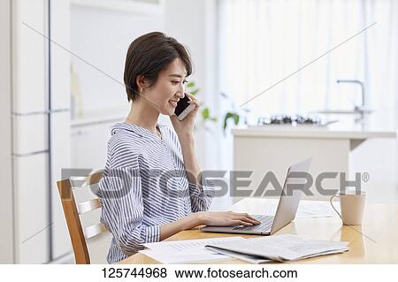 Japanese woman working from home View Large Photo Image Stock Photo - Japanese woman working from home. Fotosearch