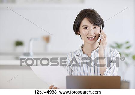 Stock Photo - Japanese woman working from home. Fotosearch