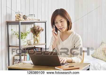 Japanese woman working from home View Large Photo Image Stock Photo - Japanese woman working from home. Fotosearch