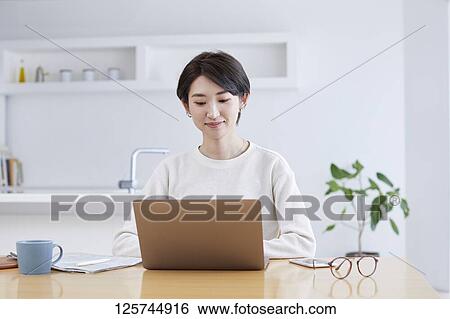 Japanese woman working from home View Large Photo Image Stock Photograph - Japanese woman working from home. Fotosearch