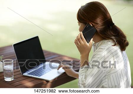 Japanese woman working with laptop in the garden View Large Photo Image Stock Image - Japanese woman working with laptop in the garden. Fotosearch