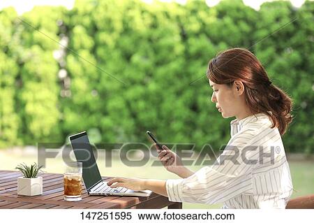 Japanese woman working with laptop in the garden View Large Photo Image Stock Photography - Japanese woman working with laptop in the garden. Fotosearch
