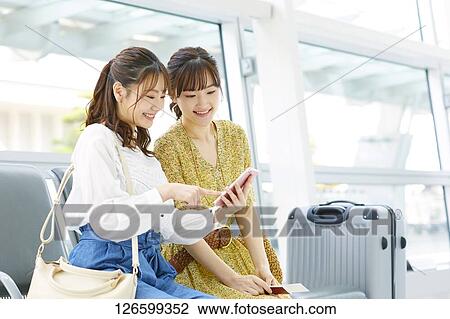 Stock Image - Japanese women at the airport. Fotosearch