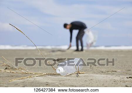 Man cleaning beach from garbage View Large Photo Image Picture - Man cleaning beach from garbage. Fotosearch
