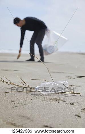 Man cleaning beach from garbage View Large Photo Image Stock Photography - Man cleaning beach from garbage. Fotosearch