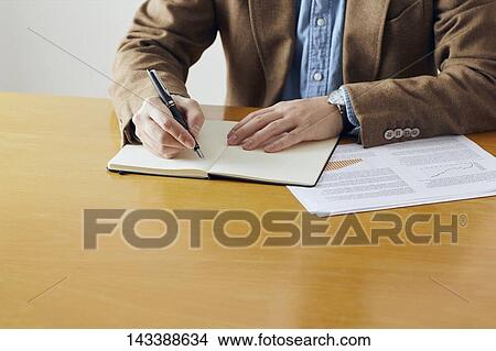 Picture - Man writing on paper. Fotosearch