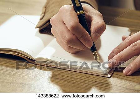 Stock Image - Man writing on paper. Fotosearch