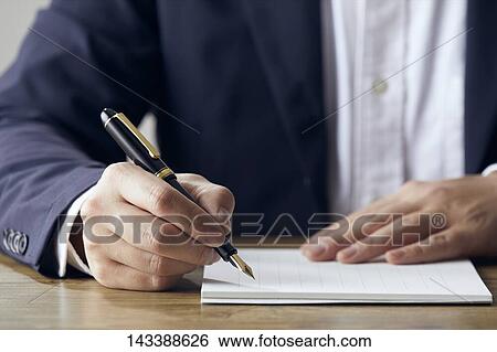 Stock Photograph - Man writing on paper. Fotosearch