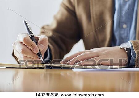 Stock Photograph - Man writing on paper. Fotosearch