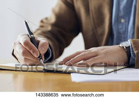 Stock Photography - Man writing on paper. Fotosearch