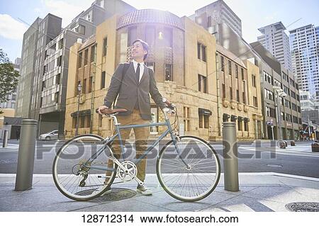 Middle Aged Japanese Businessman Riding A Bicycle View Large Photo Image Picture - Middle Aged Japanese Businessman Riding A Bicycle. Fotosearch