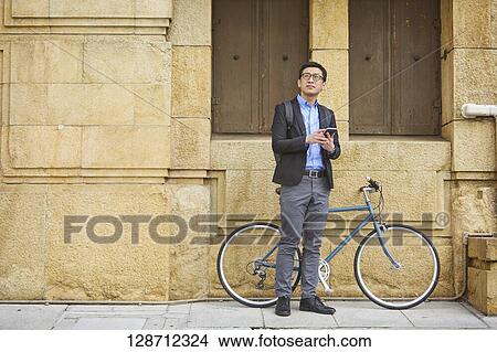 Middle Aged Japanese Businessman Riding A Bicycle View Large Photo Image Picture - Middle Aged Japanese Businessman Riding A Bicycle. Fotosearch