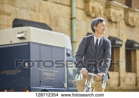 Middle Aged Japanese Businessman Riding A Bicycle View Large Photo Image Picture - Middle Aged Japanese Businessman Riding A Bicycle. Fotosearch