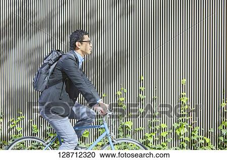 Stock Image - Middle Aged Japanese Businessman Riding A Bicycle. Fotosearch