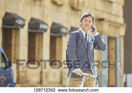 Middle Aged Japanese Businessman Riding A Bicycle View Large Photo Image Stock Image - Middle Aged Japanese Businessman Riding A Bicycle. Fotosearch