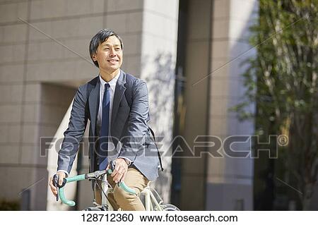 Middle Aged Japanese Businessman Riding A Bicycle View Large Photo Image Stock Image - Middle Aged Japanese Businessman Riding A Bicycle. Fotosearch